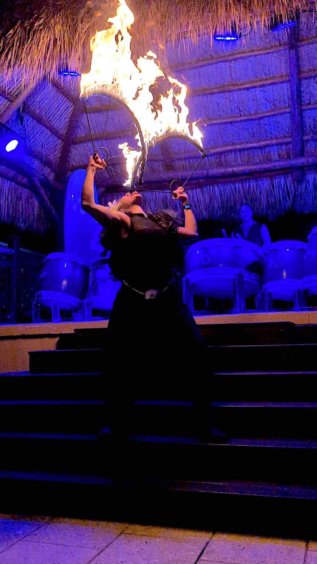 Fire dancer performing under the tiki roof at Tiki Fever